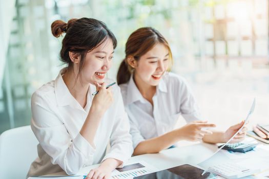 Negotiation, Analysis, Discussion: Portrait of an Asian woman economist and marketer pointing to a financial data sheet to plan investments to prevent risks and losses for the company.