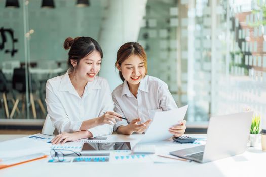 Negotiation, Analysis, Discussion: Portrait of an Asian woman economist and marketer pointing to a financial data sheet to plan investments to prevent risks and losses for the company.