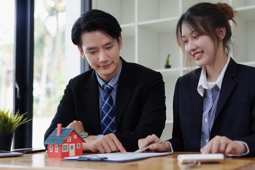 Guarantees, mortgages, signing, interest on loans, real estate agents are making agreements with customers to buy houses and land and sign contract documents.