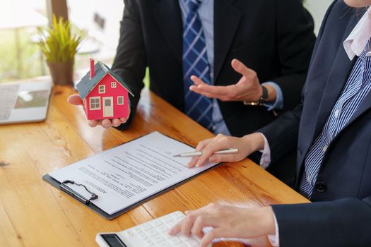 Guarantees, mortgages, signing, interest on loans, real estate agents are making agreements with customers to buy houses and land and sign contract documents.