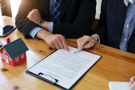 Guarantees, mortgages, signing, interest on loans, real estate agents are making agreements with customers to buy houses and land and sign contract documents.