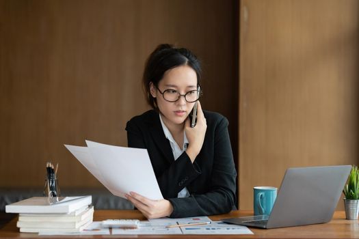 Image of Young woman with a cell phone working online on laptop computer. studying or working from home online concept