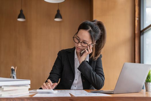 Busy business accountant woman making call phone in office and business working background, tax, accounting, statistics and analytic research concept.