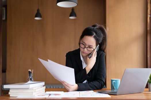 Busy business accountant woman making call phone in office and business working background, tax, accounting, statistics and analytic research concept.