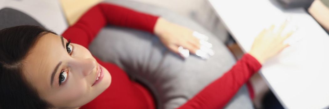 Top view of brunette young woman sitting on appointment in beauty studio. Nail master cover nails with polish. Self care, spa procedure, wellness concept