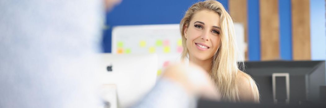 Portrait of young attractive woman smile on camera and posing in company office. Beautiful blonde employee work in big corporation. Career, success concept