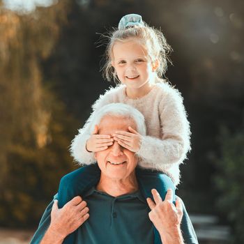 Shot of a girl being carried by her grandfather outside.