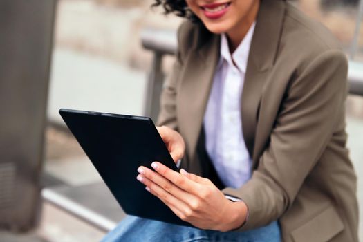 close-up of the hands of an unrecognizable young woman using a tablet, concept of technology and urban lifestyle