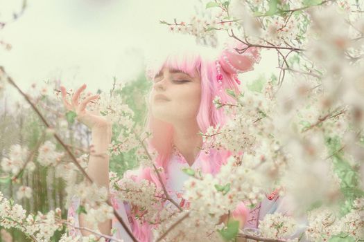 Portrait of young european woman wearing kimono. Asian beauty. Cherry blossoms. Hanami. Sightseeing of Japan concept.