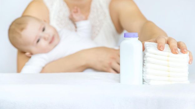 mother changes baby's diaper on a light background. Selective focus. people.