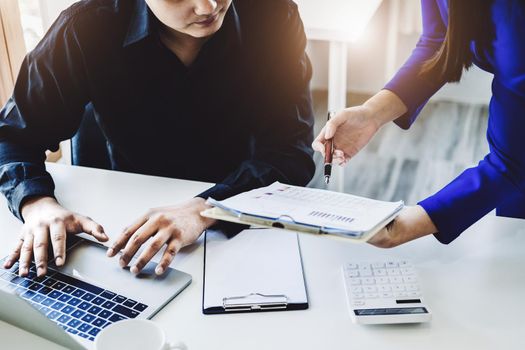 Teamwork concept, consultation, female advisor pointing to budget, finance and investment papers, discussing and planning finances with male economists in conference room