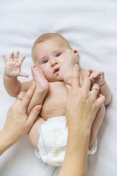 Mother massage baby on the bed. Selective focus. people.