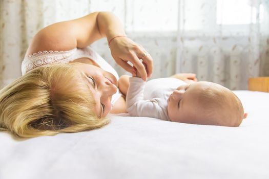 Mother with baby on a light background. Selective focus. People.