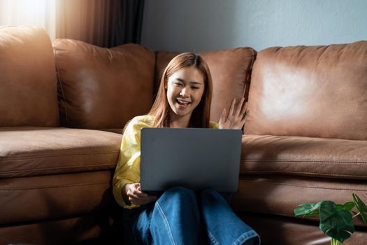 Young asian woman using video chat on laptop in home.