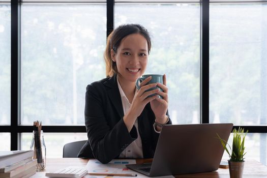 Business accountant woman using calculator with computer laptop, Business accounting, budget and loan paper in office
