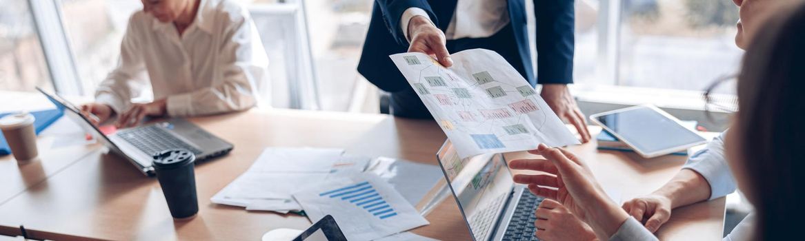 Close up of business people consider documents with charts in a modern office. Teamwork concept