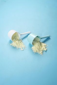 Close up of baby milk powder and spoon on tile background