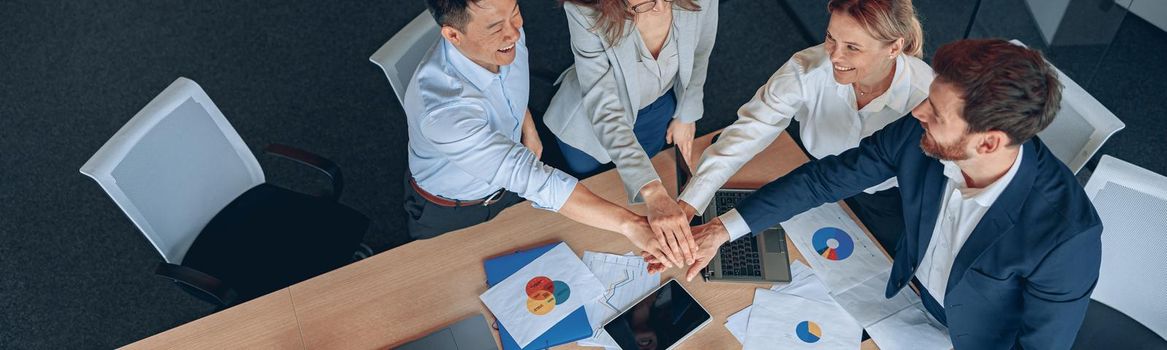 Happy successful multiracial business team showing unity with their hands. High quality photo