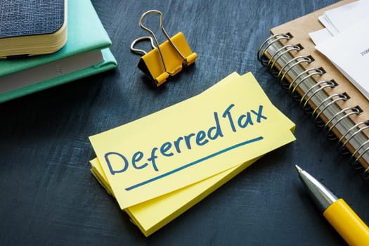 Deferred tax written on a sticker and papers.