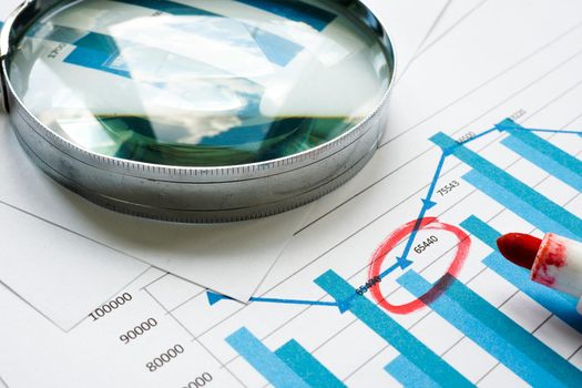 A Magnifying glass and financial report. Internal Controls and audit concept.