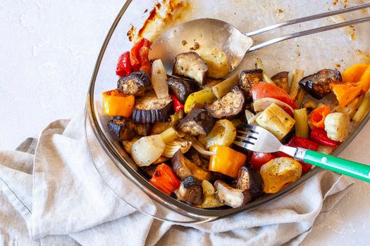 oven dish with baked vegetables, family size, half eaten, top view, copy space