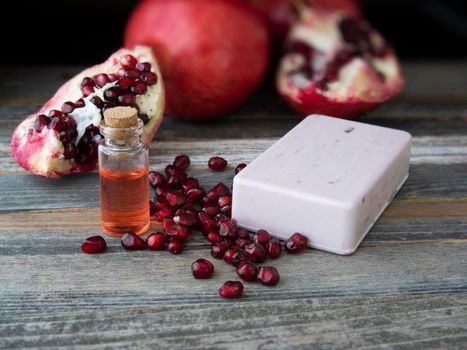 Pomegranate extract soap with a small bottle of extrace and pieces of a pomegranate.