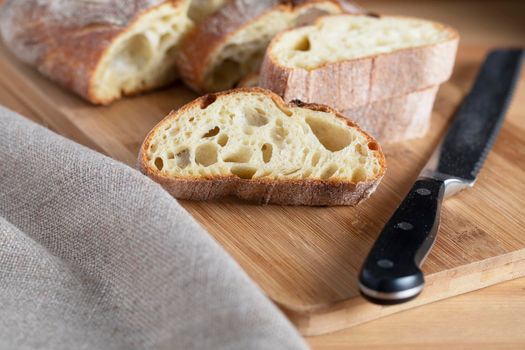 Slice of rustic bread on cutting board with knife