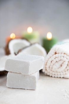 Coconut soap with towels and candles for a relaxing spa experience.