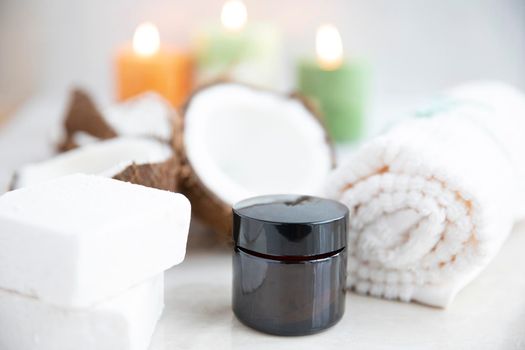 Small brown jar of coconut cosmetic product in spa environment.
