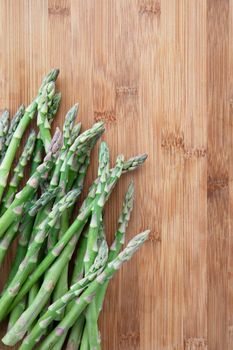 Fresh raw asparagus on cutting board with copy space.