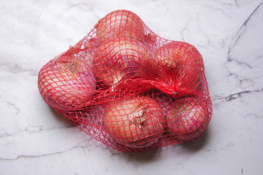 fresh onion in a reusable shopping bag ,