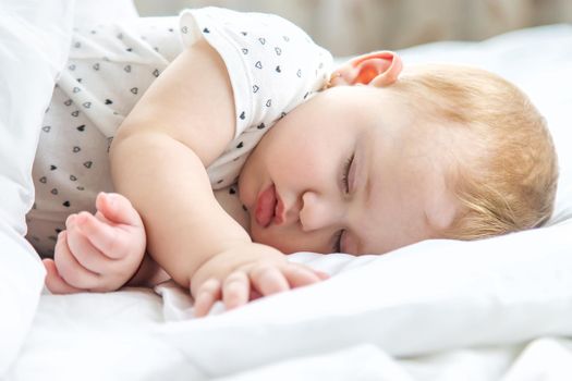 Baby sleeps on a white bed. Selective focus. Child.