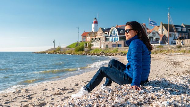 Urk Flevoland Netherlands, a day at the old village of Urk with fishing boats at the harbor. Urk harbor. Urk Lighthouse at the lake Ijsselmeer, woman on the ebach