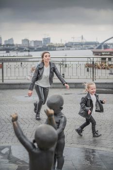 mother plays with her daughter in the city