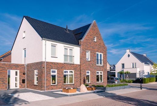 Dutch Suburban area with modern family houses, newly build modern family homes in the Netherlands, dutch family houses, and apartment houses. In the Netherlands, newly build streets with modern house