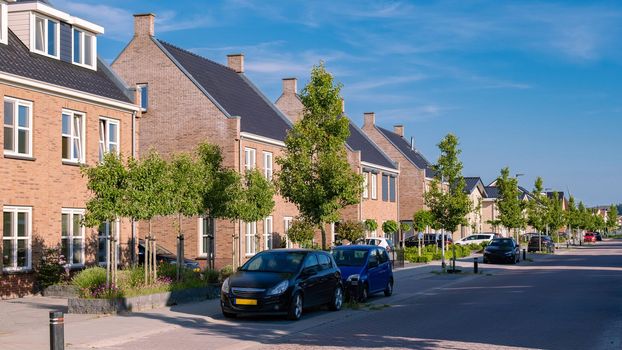 Dutch Suburban area with modern family houses, newly build modern family homes in the Netherlands, dutch family houses, and apartment houses. In the Netherlands, newly build streets with modern house