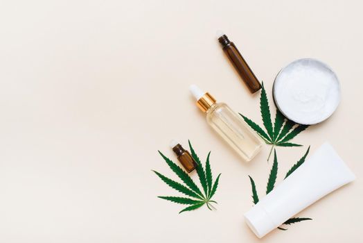 Cosmetics with hemp extract on a beige background with copy space