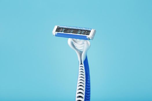 Three shaving machines on a blue background with free space, top view