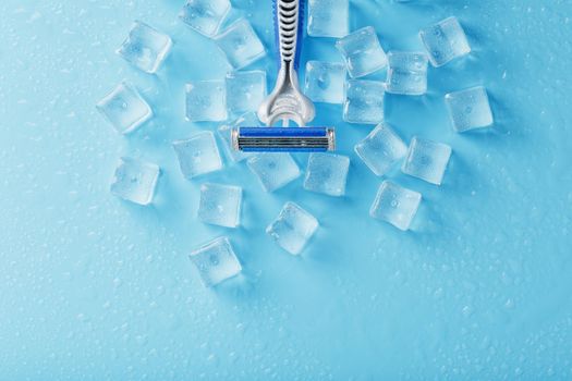 Blue shaving machines in a row on a blue background with ice cubes. The concept of cleanliness and frosty freshness