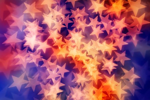 Star shaped bokeh background in yellow, reds and purple tones.