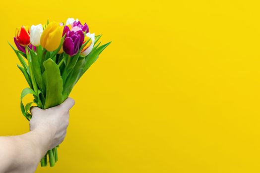 Bouquet of flowers on a yellow background. Congratulations on the holiday, March 8, Valentine's Day or birthday. Multicolored tulips.Copy space