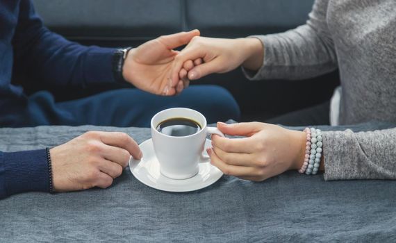 Man and woman at the table with a cup of coffee. Selective focus. People.