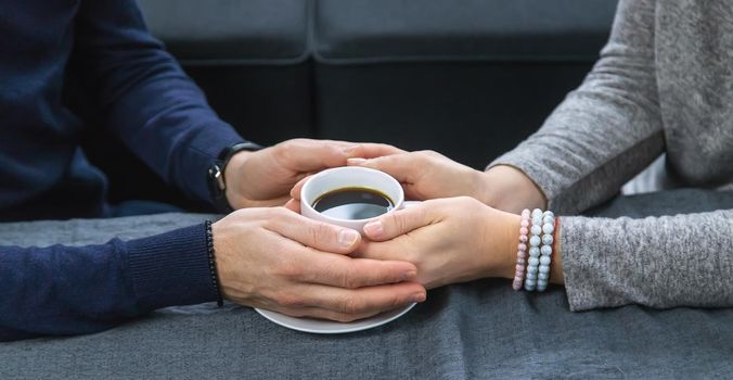 Man and woman at the table with a cup of coffee. Selective focus. People.