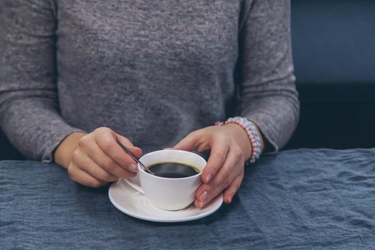 Woman at the table with a cup of coffee. Selective focus. Drink.