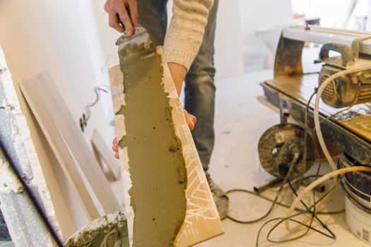 smear the tile repair in the house with a solution. Selective focus. white.