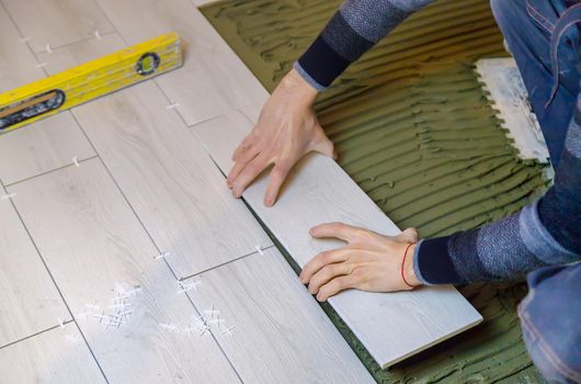 lay tiles on the floor in the house. Selective focus. white.