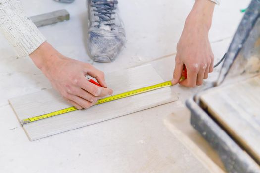 measure tile repair in the house. Selective focus. white.