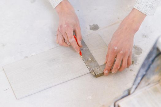 measure tile repair in the house. Selective focus. white.