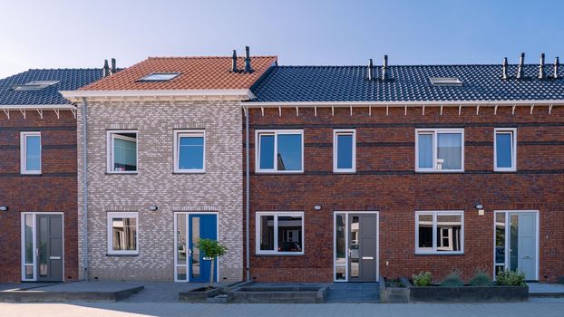 Dutch Suburban area with modern family houses, newly build modern family homes in the Netherlands, dutch family houses, and apartment houses. In the Netherlands, newly build streets with modern house