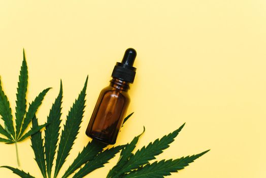 Hemp oil on a yellow background with copy space. Serum with cannabis extract. Natural skin care